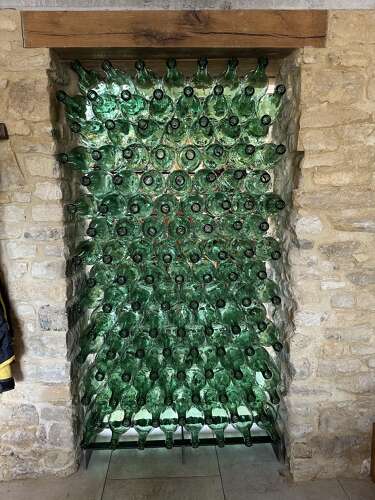 A WALL OF LARGE GREEN COGNAC BOTTLES, FRANCE C1935